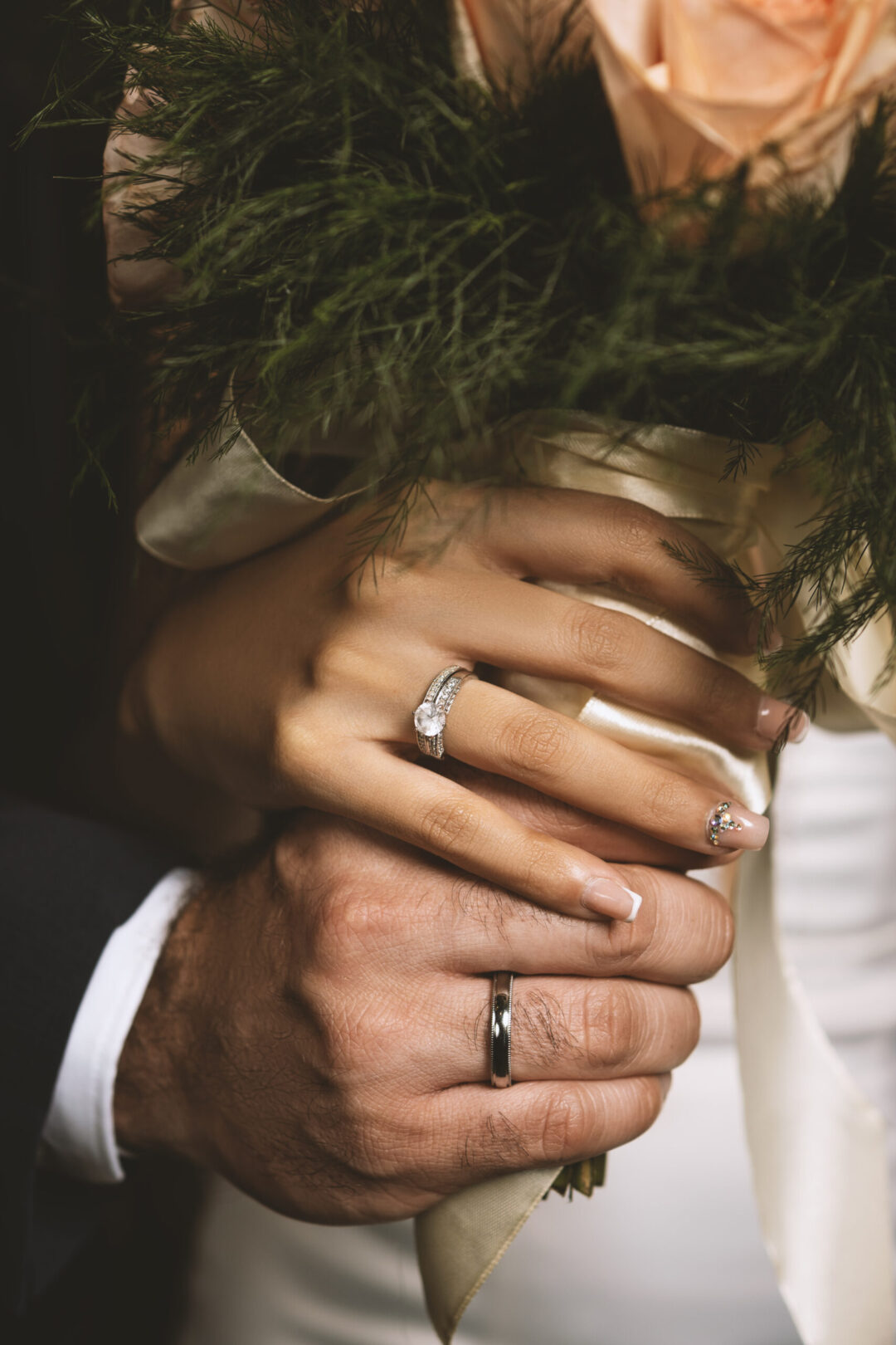 Bride and groom holding hands and wedding bouquet