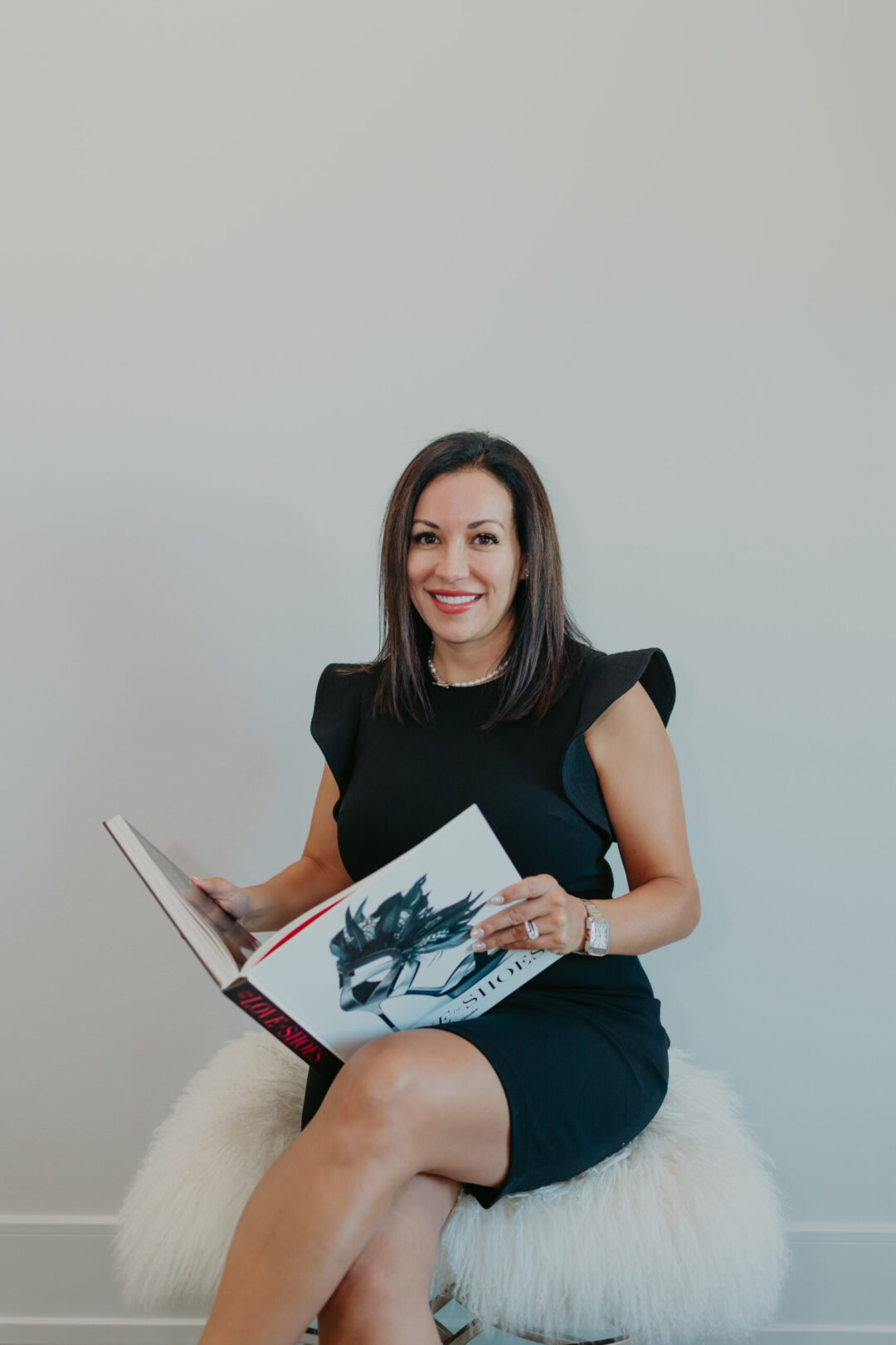 Immigration attorney Gilda McDowell smiling while holding a book